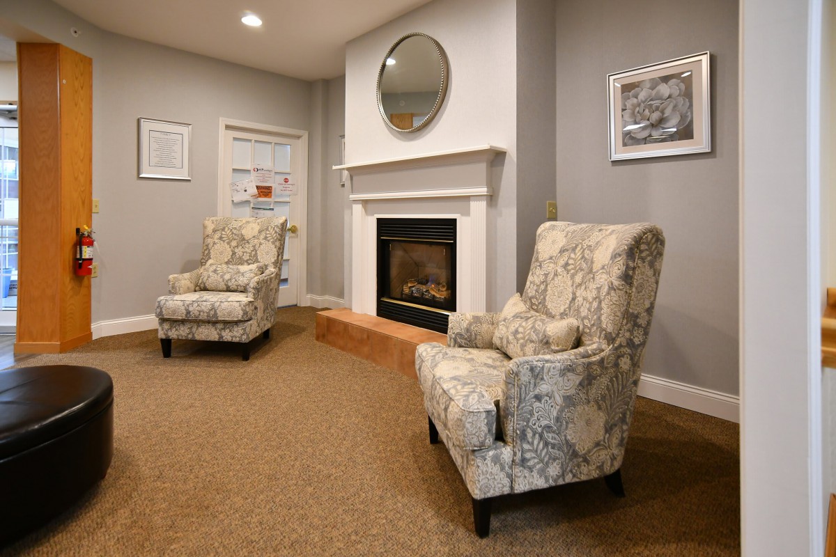 A cozy living room with patterned chairs and a fireplace.