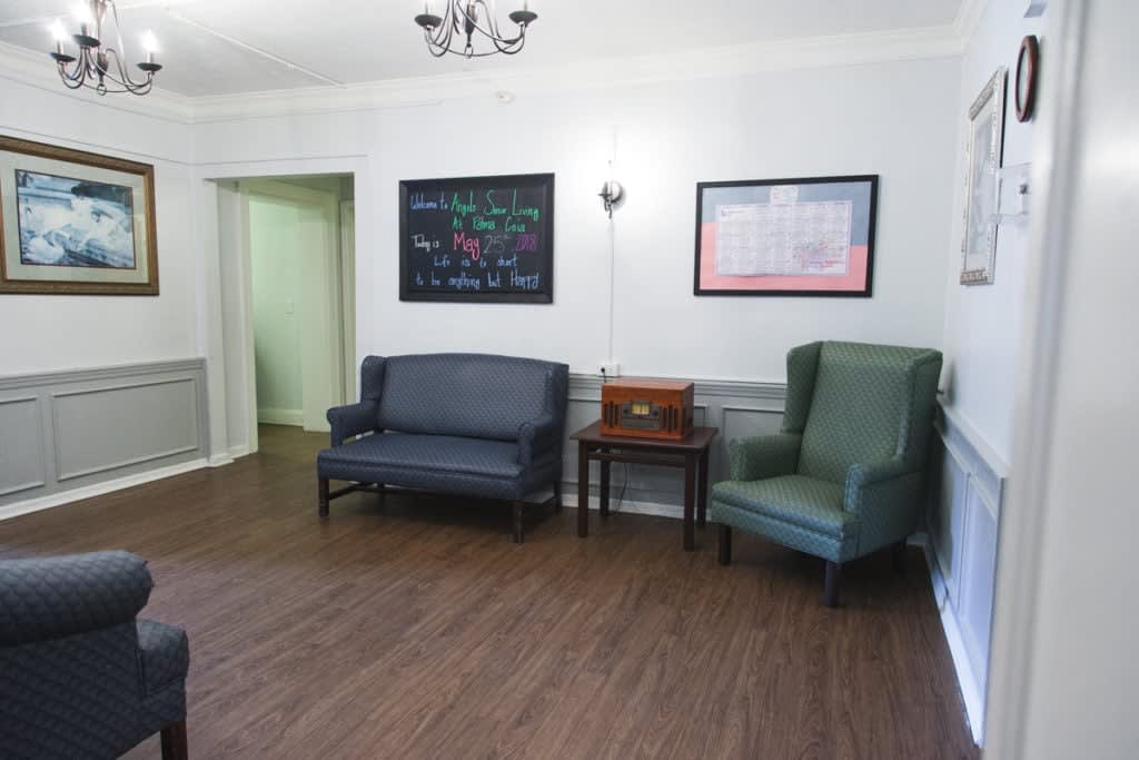 A cozy waiting room with comfortable seating and wall decorations.