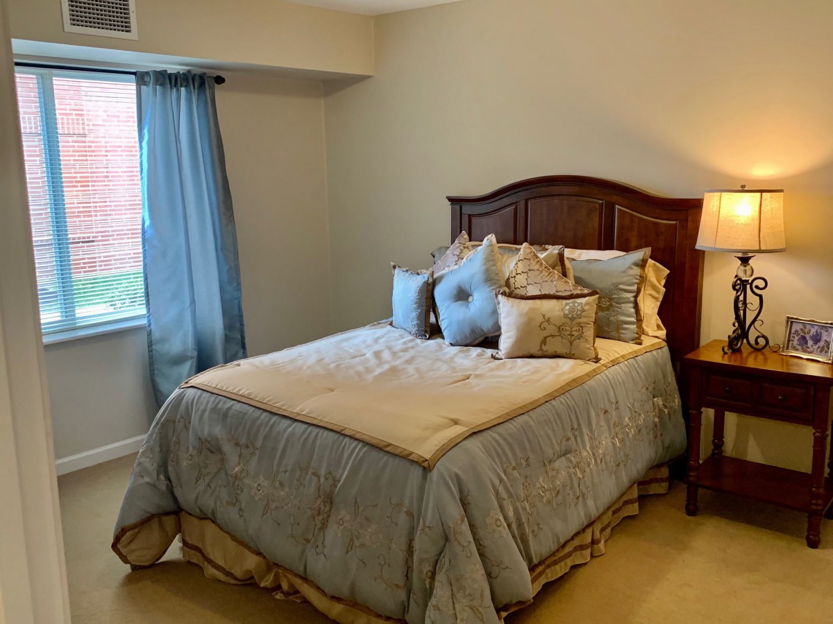 A cozy bedroom with a neatly made bed and soft lighting.