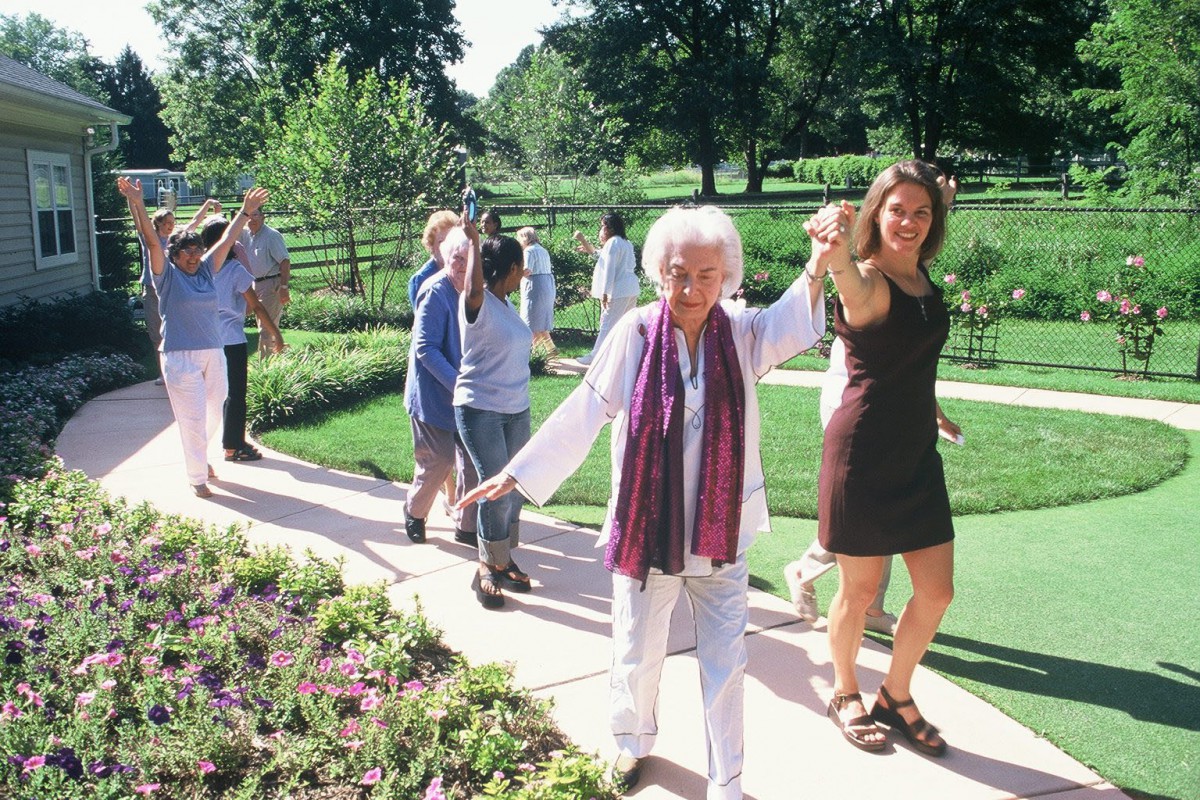 A group of people walking together in a sunny garden.