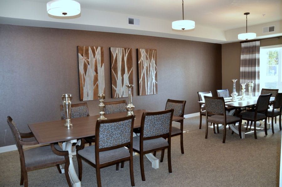 A modern dining room featuring a large wooden table, elegant chairs, and contemporary artwork on the walls.