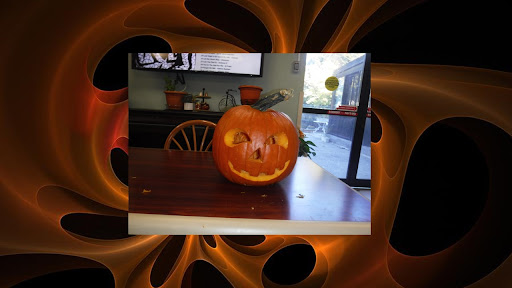 A creatively carved Halloween pumpkin displayed on a table.