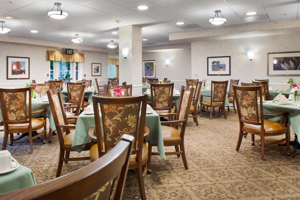 A spacious and elegantly decorated dining room with wooden chairs and tables.