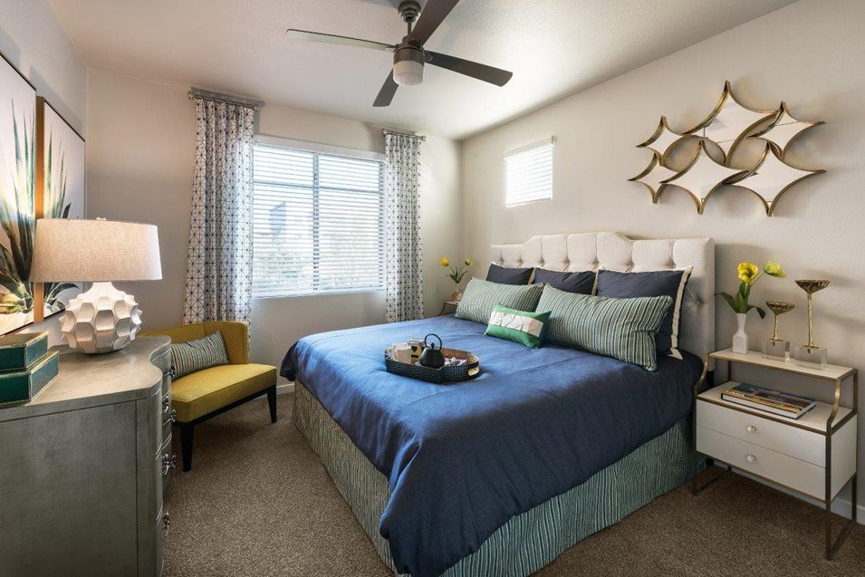 A modern bedroom with blue bedding and stylish decor.