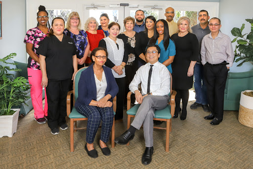 A diverse team of professionals gathered for a group photo in an office setting.