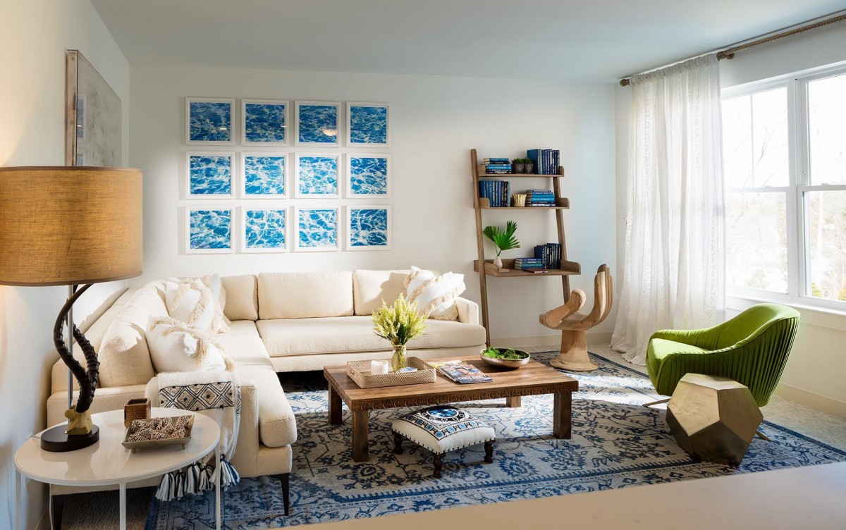 A stylish living room featuring a cozy white sofa, wooden coffee table, and wall-mounted artwork.