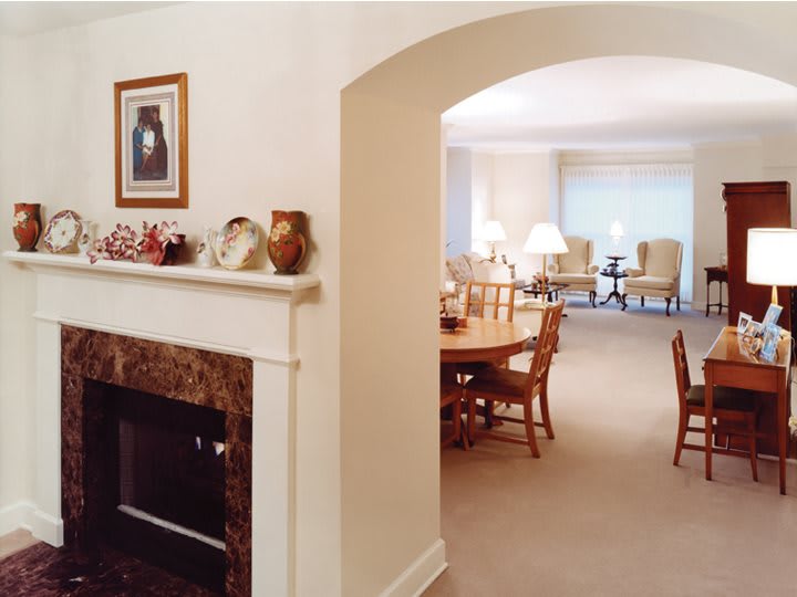 A cozy living and dining area featuring a fireplace, traditional furniture, and neutral tones.