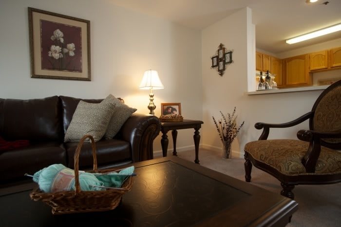 A cozy living room with a leather sofa, side table, and warm lighting.
