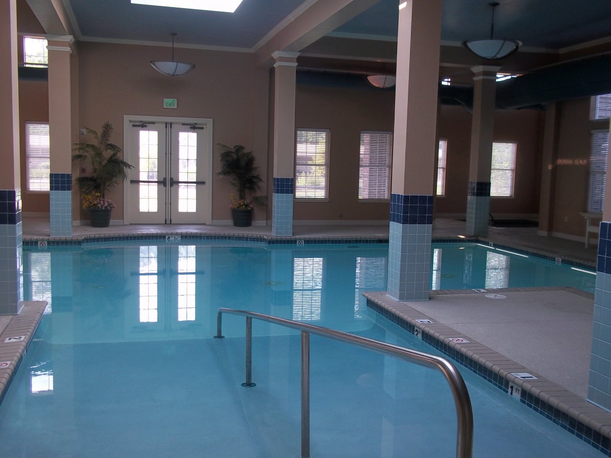 An indoor swimming pool area with pillars and natural light.
