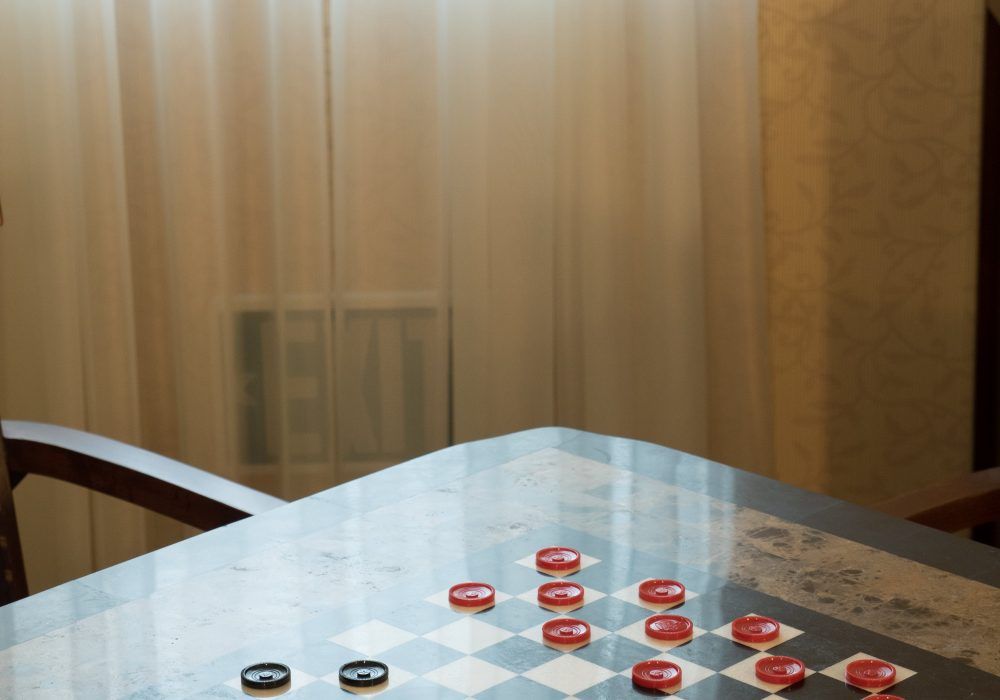 A checkers game in progress on a table.