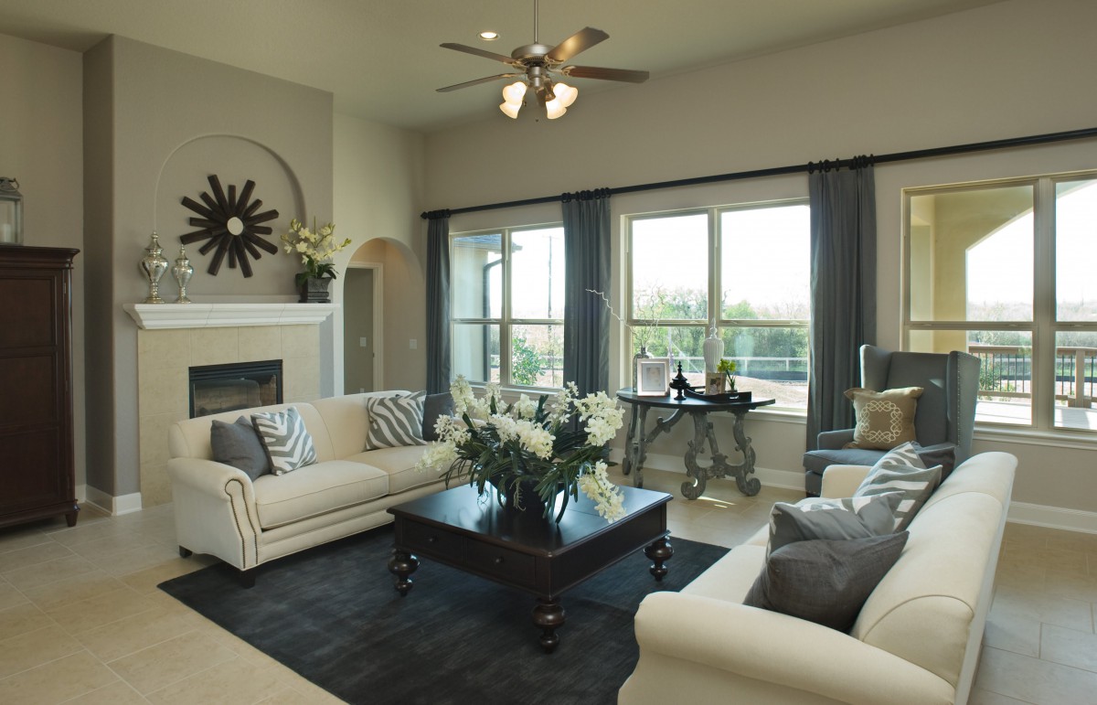 A stylish living room featuring elegant furniture and large windows, with a cozy fireplace as a focal point.