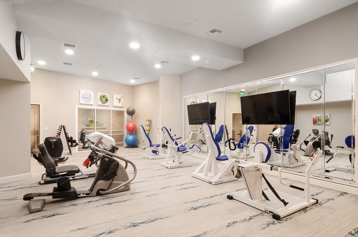 A well-equipped gym featuring various exercise machines and a spacious workout area.