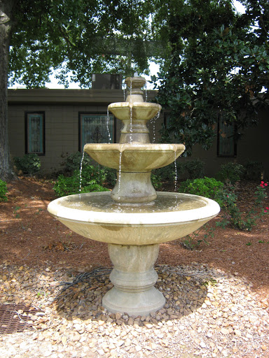 A beautiful tiered fountain surrounded by lush greenery.