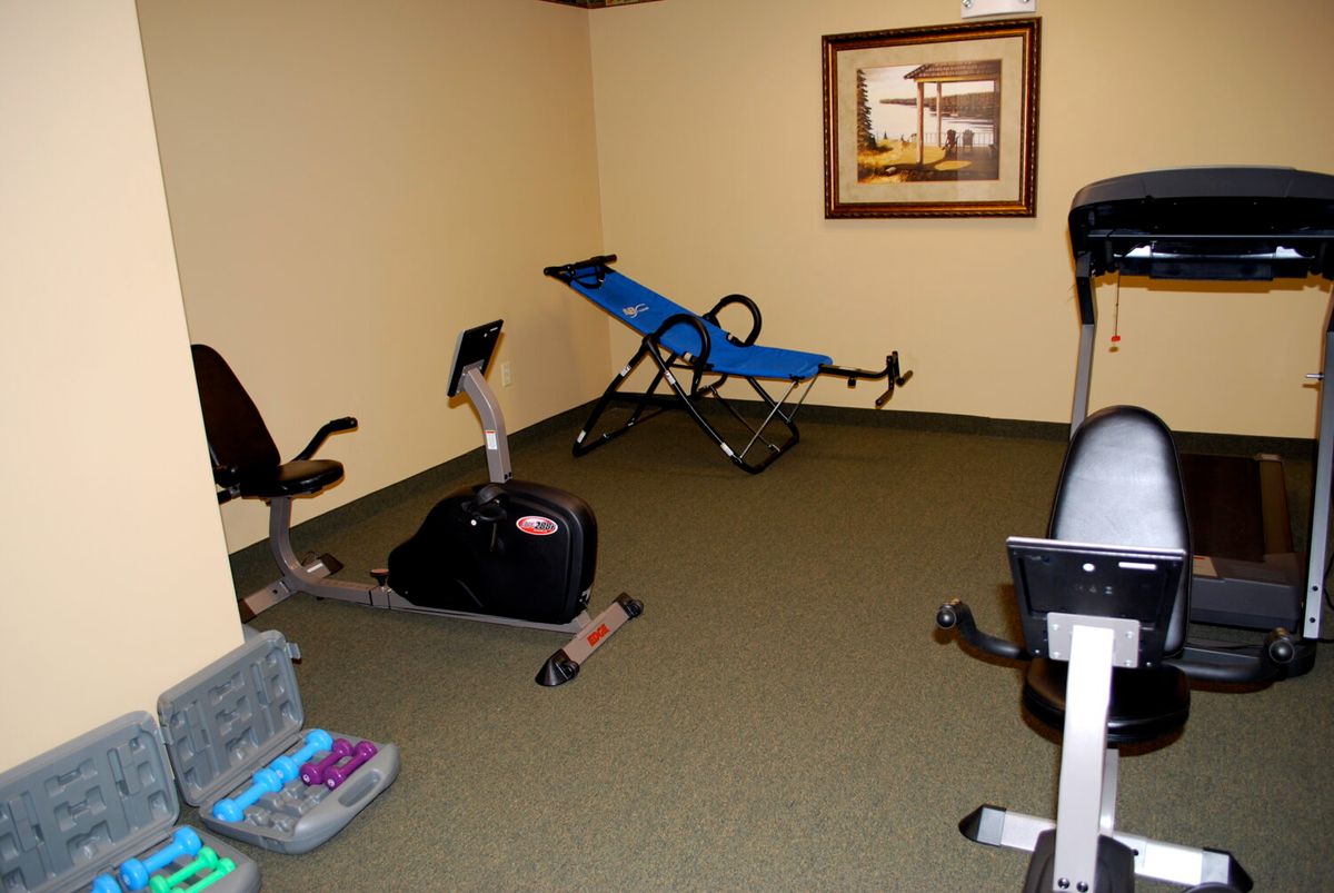 A small home gym with exercise equipment, including stationary bikes and other fitness gear.