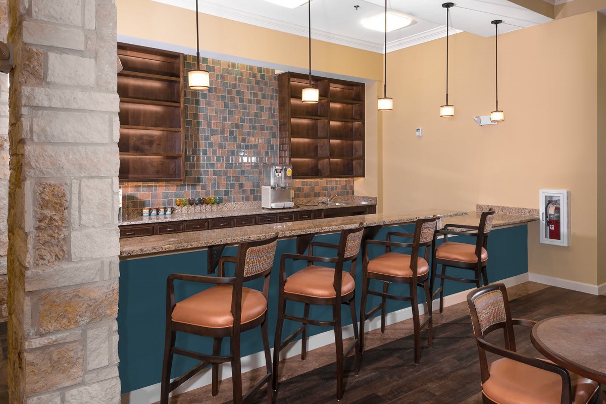 A cozy bar area with high stools and pendant lighting.