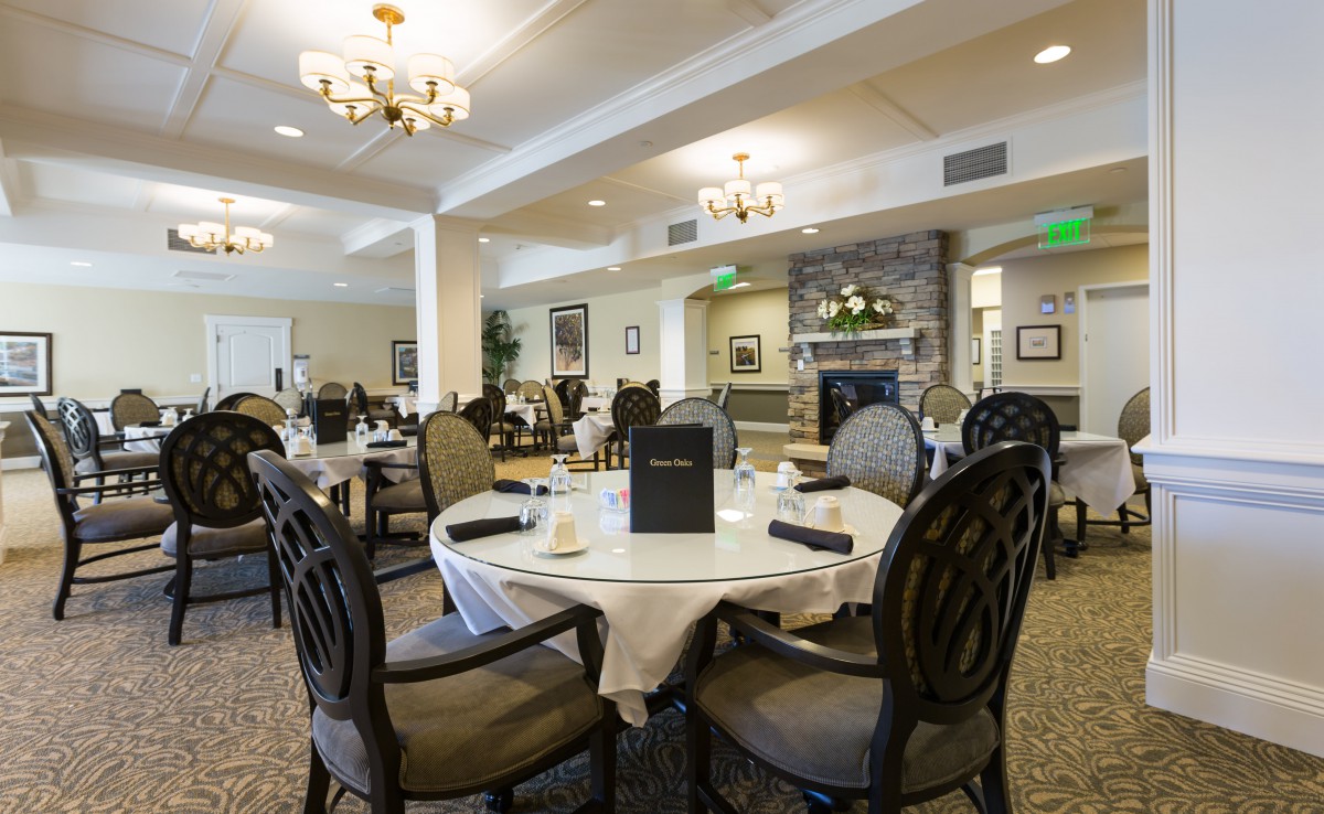 An elegant dining area with neatly arranged tables and chairs, sophisticated decor, and a warm ambiance.