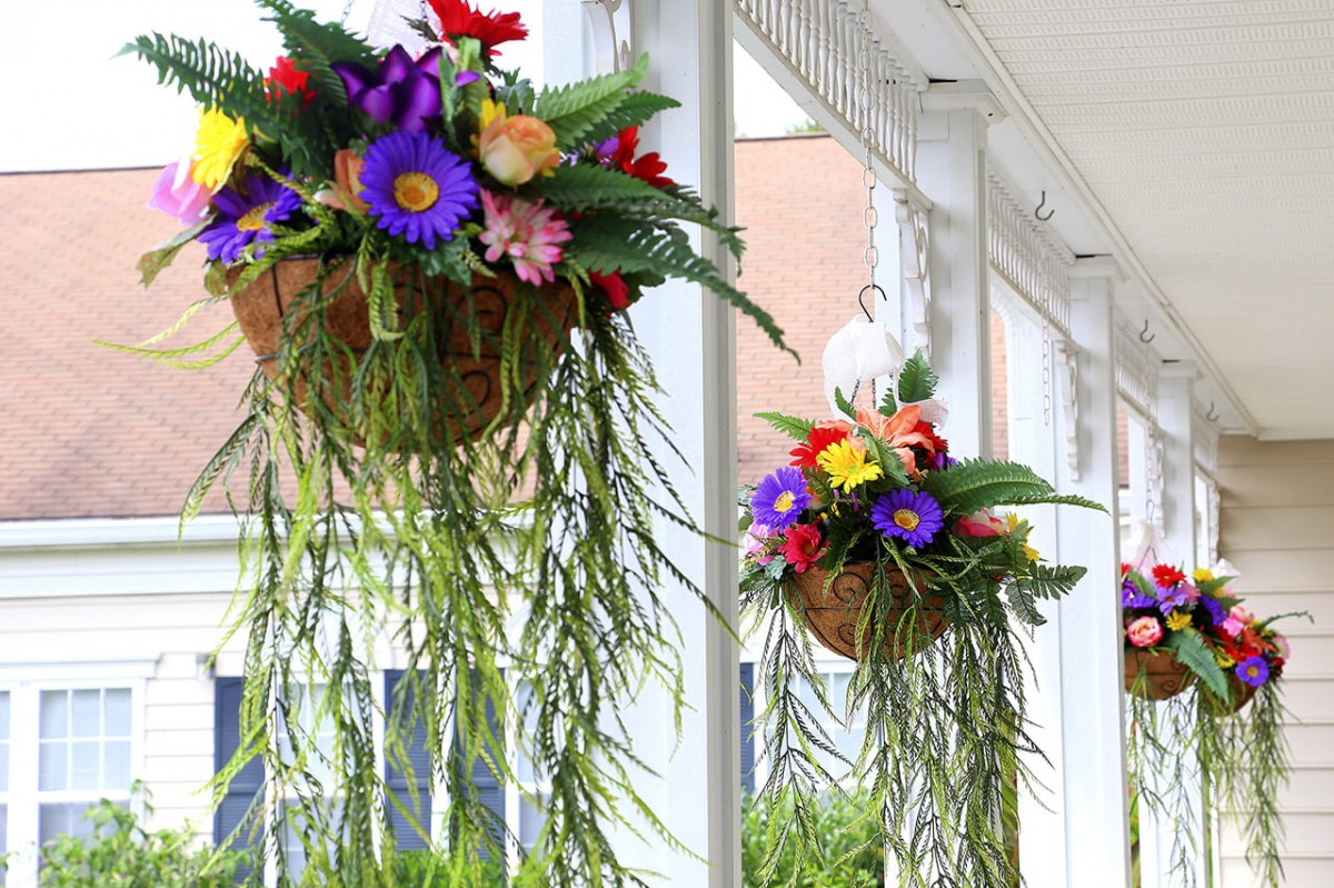 Colorful hanging flower baskets adorn a porch.