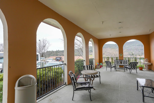 A cozy outdoor patio area featuring comfortable seating and a scenic view through arched openings.