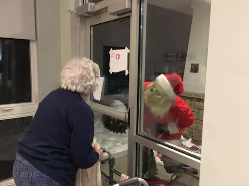 A joyful encounter between an elderly woman and Santa Claus outside a window, spreading holiday cheer.