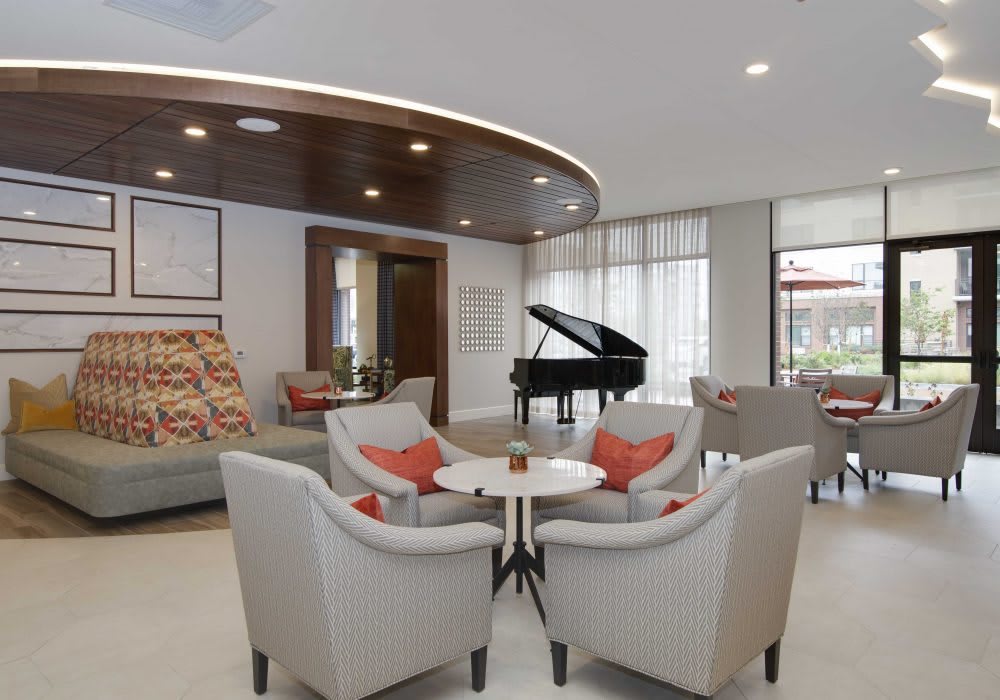 A modern lobby with a seating area and a grand piano.