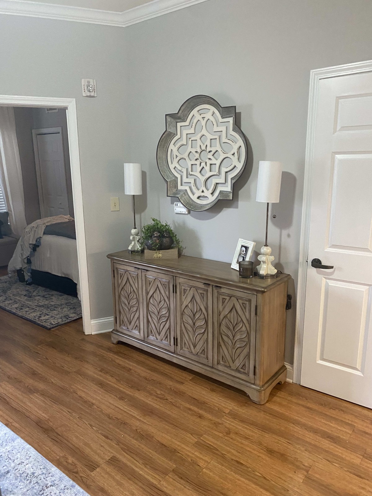 A stylish hallway with a decorative console table, two lamps, and a mirror above.