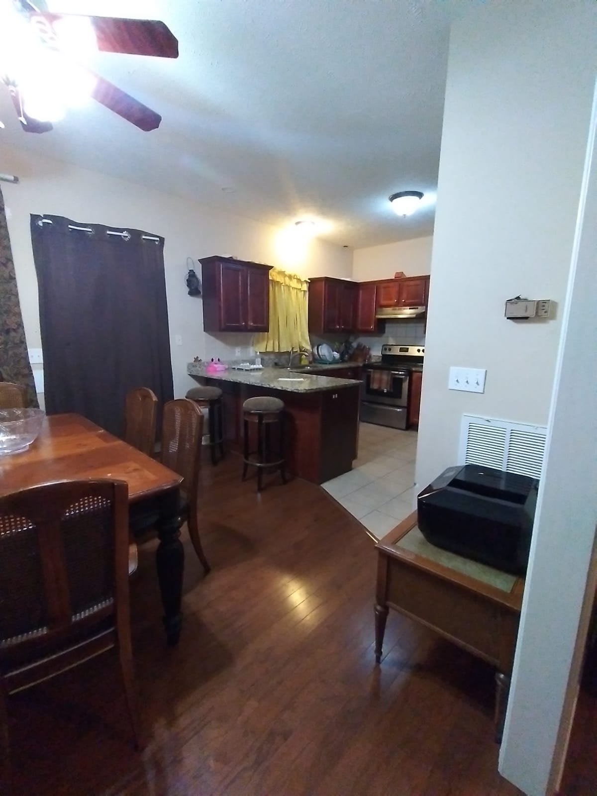 A cozy kitchen and dining area featuring wooden cabinets, a kitchen island, and a dining table with chairs.