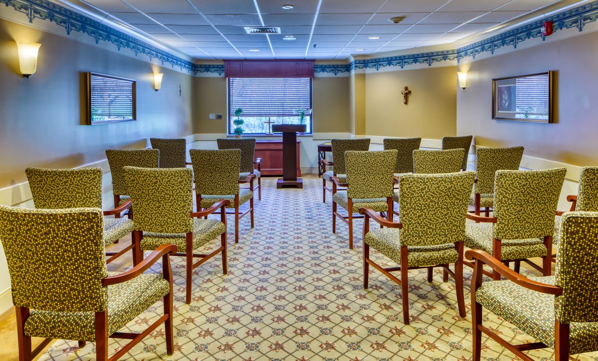 An empty meeting room with arranged chairs and a podium at the front.