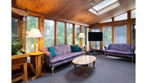 A cozy living room featuring elegant sofas and abundant natural light from the large windows.