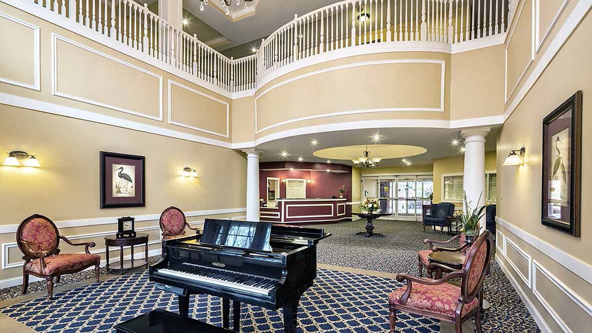 A spacious lobby featuring a grand piano and elegant interior design.