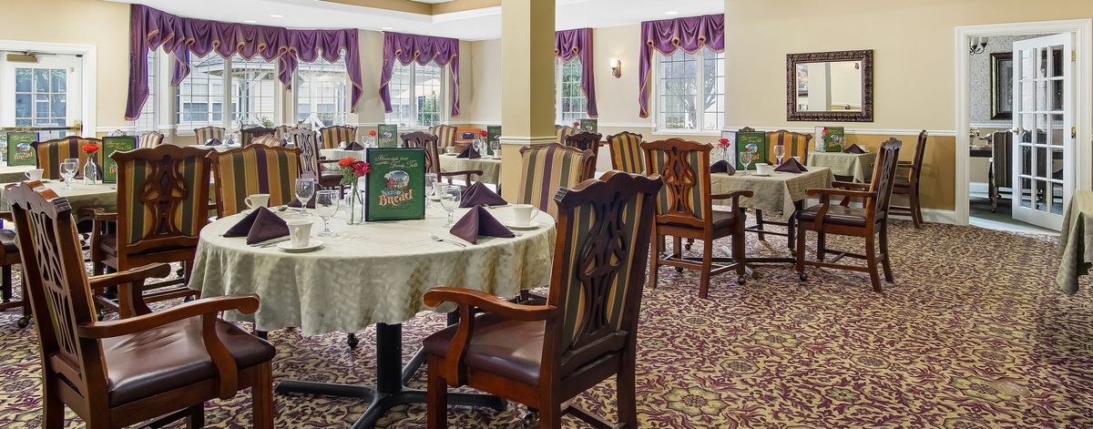 A well-appointed dining area featuring elegantly set tables with patterned chairs and warm decor.