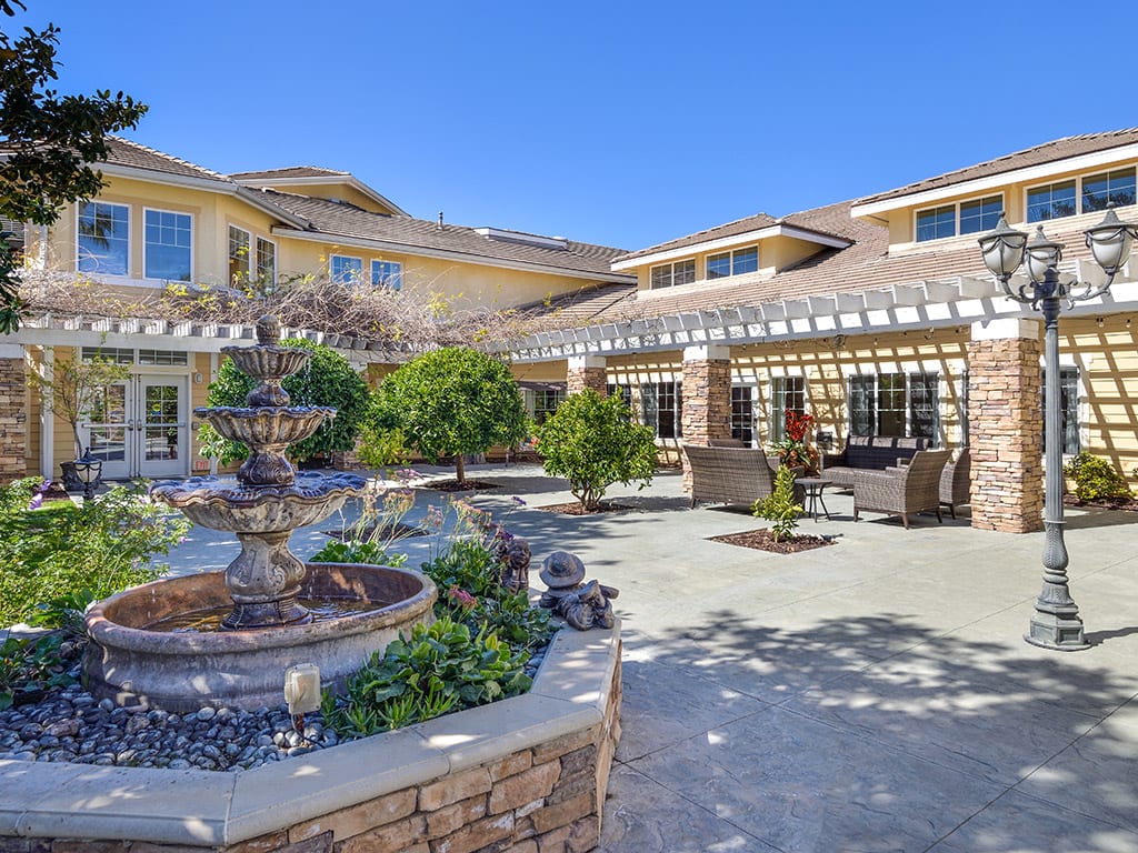 A beautiful residential courtyard featuring a fountain and well-maintained landscaping.
