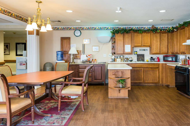 A cozy kitchen and dining area with wooden cabinets, a dining table, and chairs.