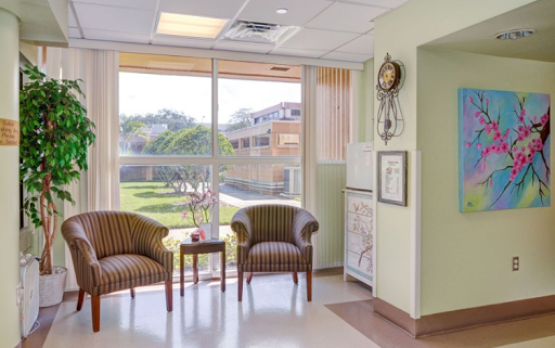 A bright and inviting waiting area in a healthcare facility, featuring comfortable armchairs and a view of the outdoors.