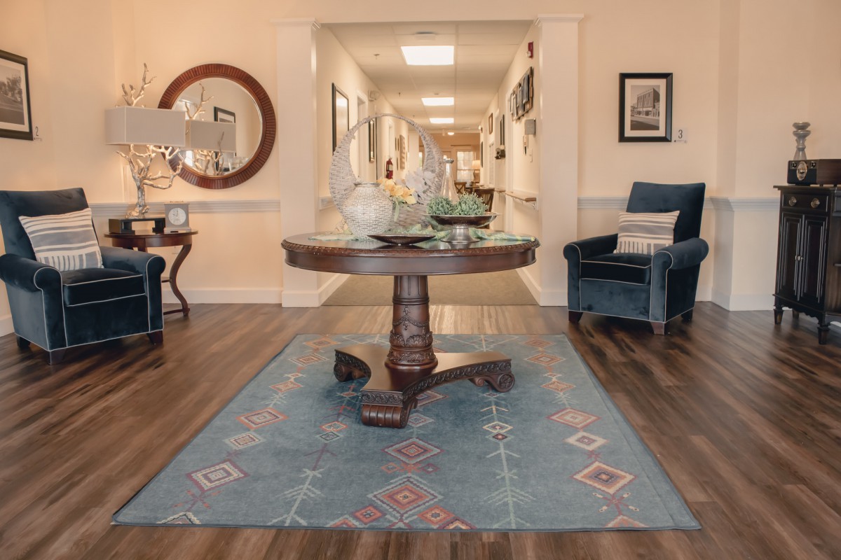 A stylish interior with a central round table and elegant decor in a well-lit hallway.