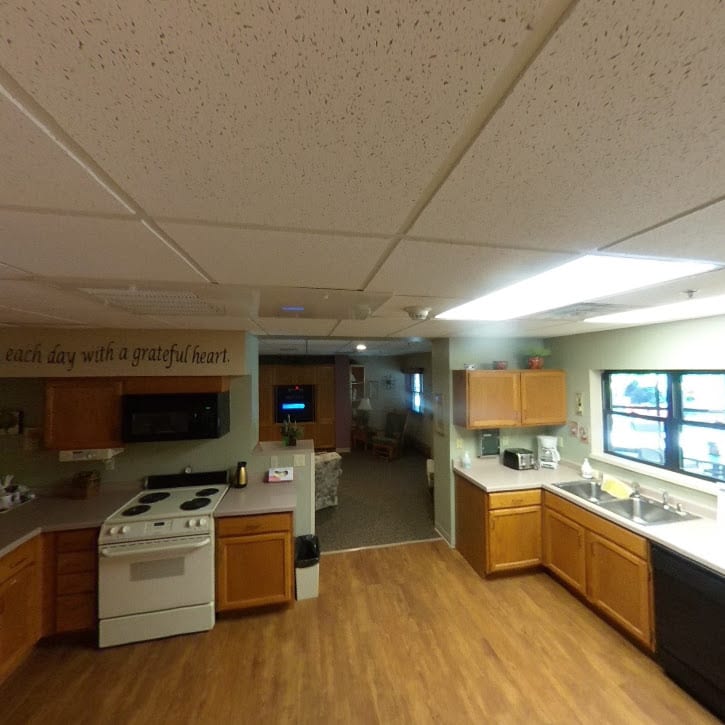 A spacious kitchen with wooden cabinets and modern appliances, featuring an oven, microwave, and a large countertop.