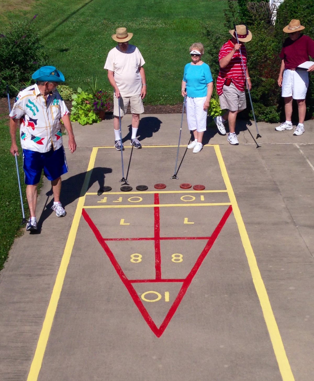 Seniors enjoying a game of shuffleboard outdoors.
