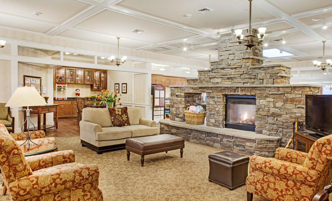A cozy living room with a stone fireplace and comfortable seating arrangements.