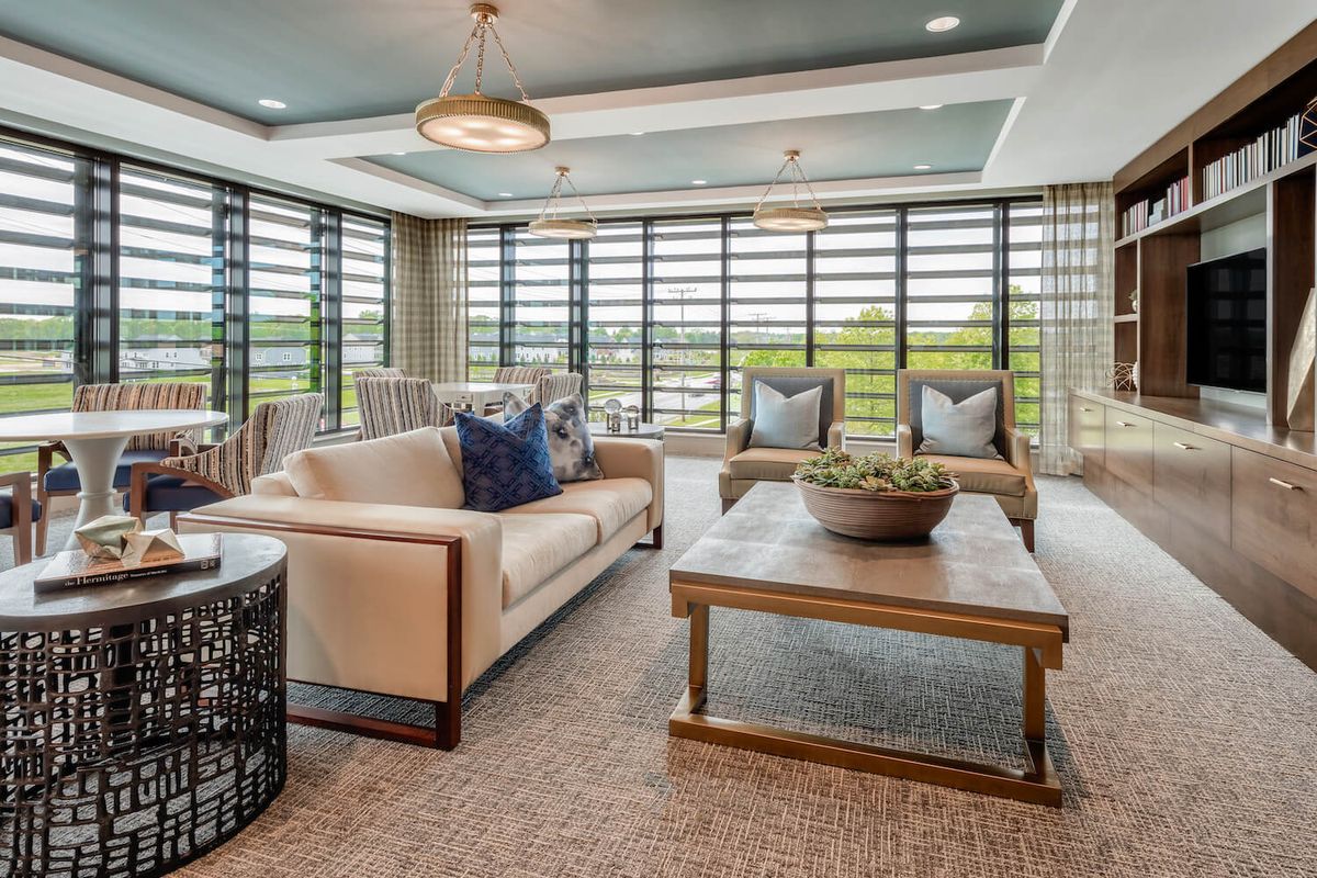 Contemporary living room with modern furniture and large windows.