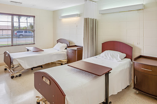 A view of a hospital patient room with two beds and a clean, serene atmosphere.
