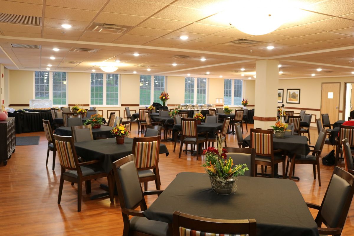 An empty restaurant dining room with neatly arranged tables and chairs.