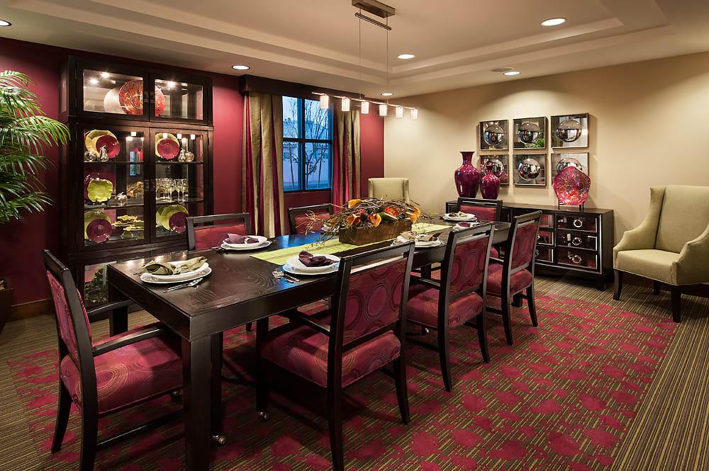 An elegantly decorated dining room with a set table, stylish chairs, and artistic decor.
