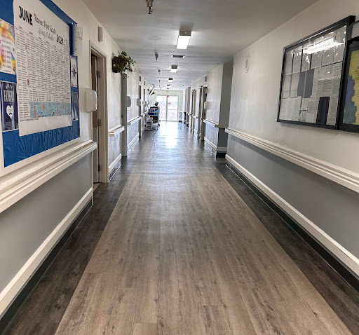 A long, well-lit hallway with a wooden floor and decorative elements.