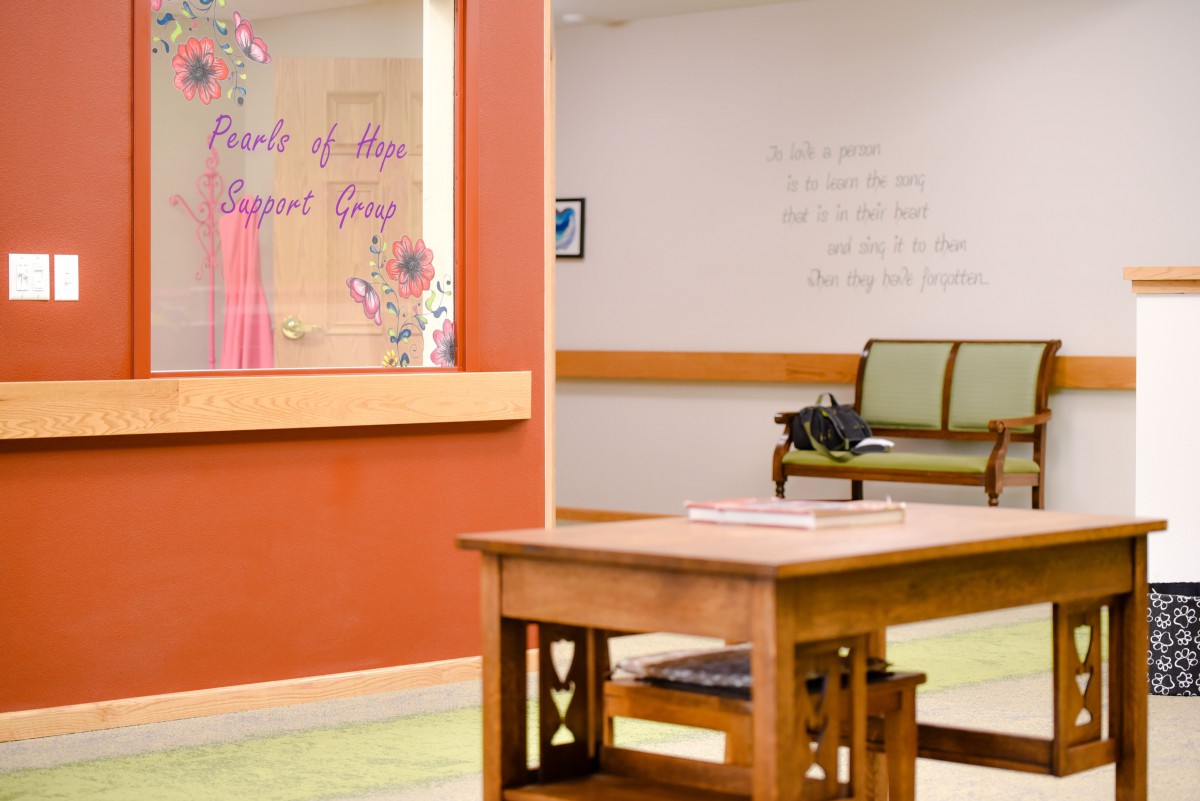 A cozy reception area with a wooden table and seating, complemented by decorative wall art.