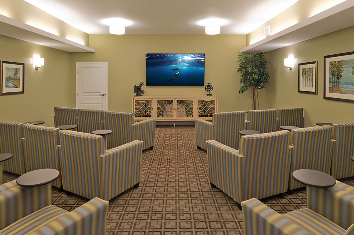 A well-arranged conference room with striped armchairs facing a large television screen.