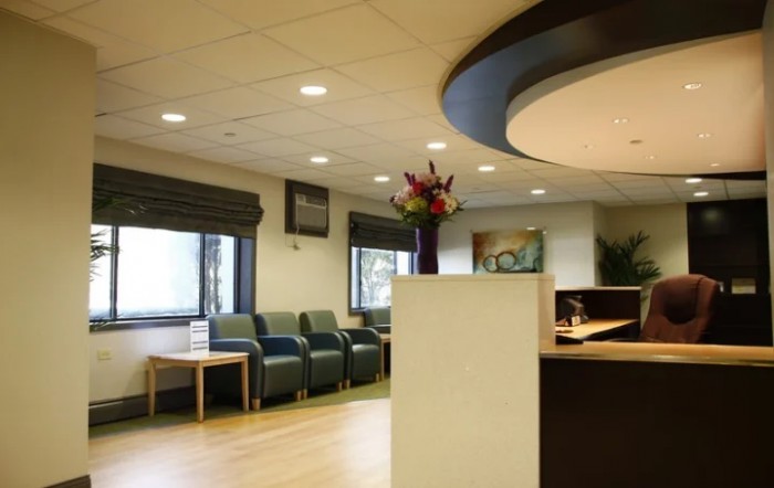 A modern waiting room with comfortable seating and a reception desk.