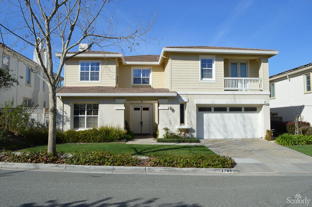 A two-story suburban house with a garage and well-maintained front yard.