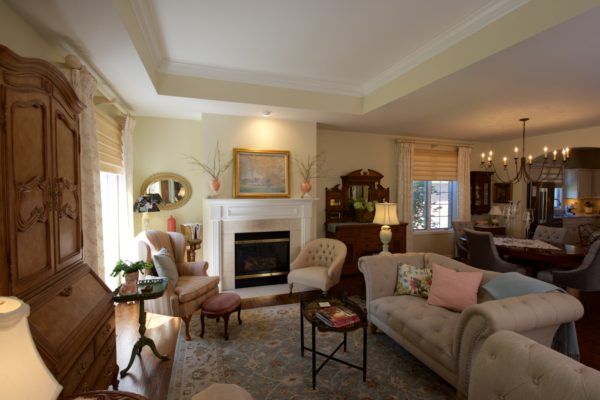A cozy living room with traditional decor, featuring sofas, a fireplace, and elegant lighting.