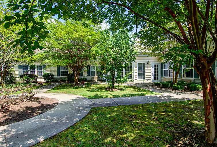 A charming residential home with a lush garden and walkway.