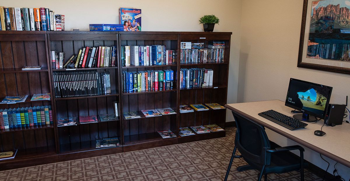 A cozy reading area with a bookshelf filled with books and a desk with a chair.