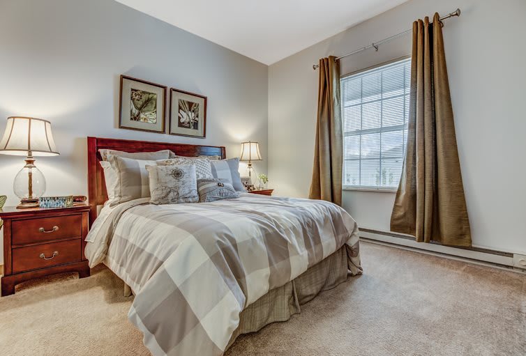 A cozy bedroom interior with a neatly made bed, soft lighting, and decorative artwork on the wall.
